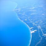 aerial view of turquoise ocean coastline with curved shoreline fine art landscape photography
