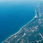 Aerial coastline landscape with turquoise ocean and curved shoreline viewed from above