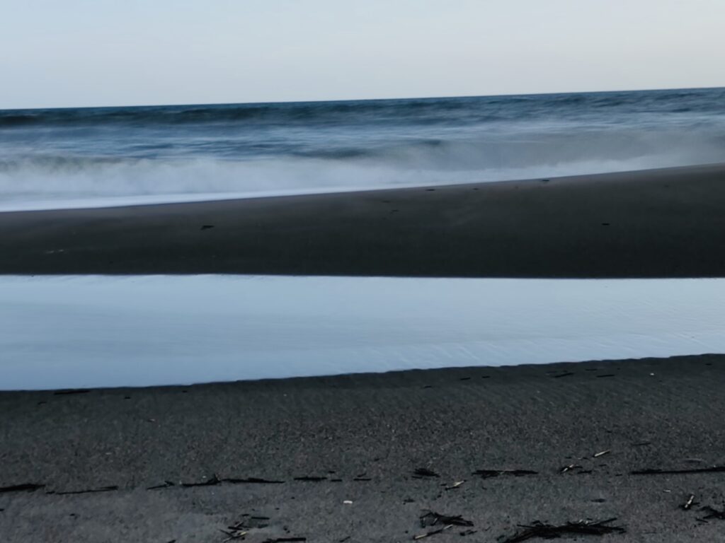 Minimal ocean shoreline with soft rolling waves – seascape photography by Layne Morgan