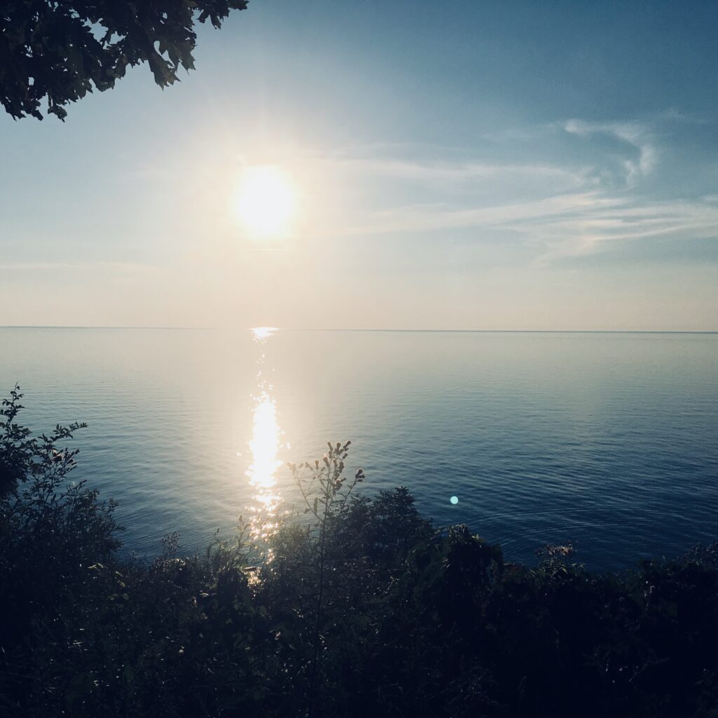 Sunlight shining through atmospheric haze over the horizon – fine art sky photography by Layne Morgan