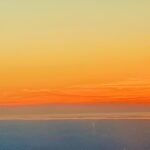 Golden sunset horizon over calm ocean sky – fine art atmospheric photography by Layne Morgan