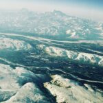 Aerial view of icy river patterns and frozen landscape from above