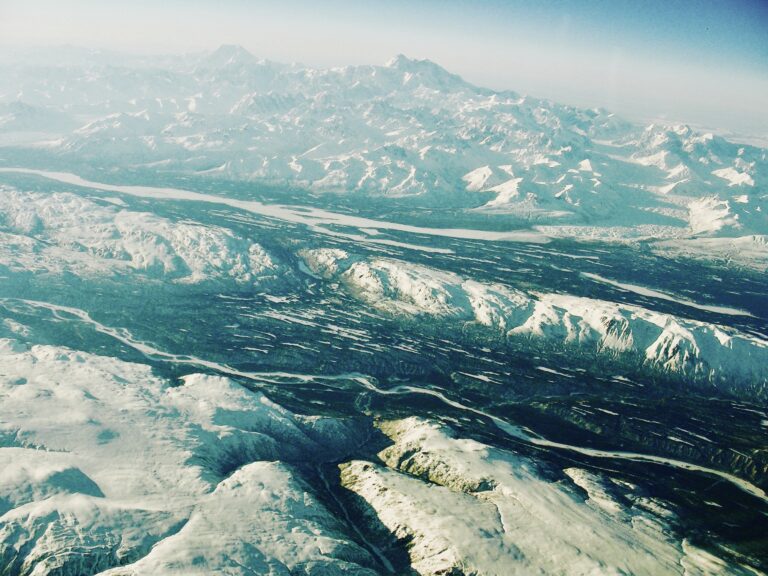 Aerial view of icy river patterns and frozen landscape from above