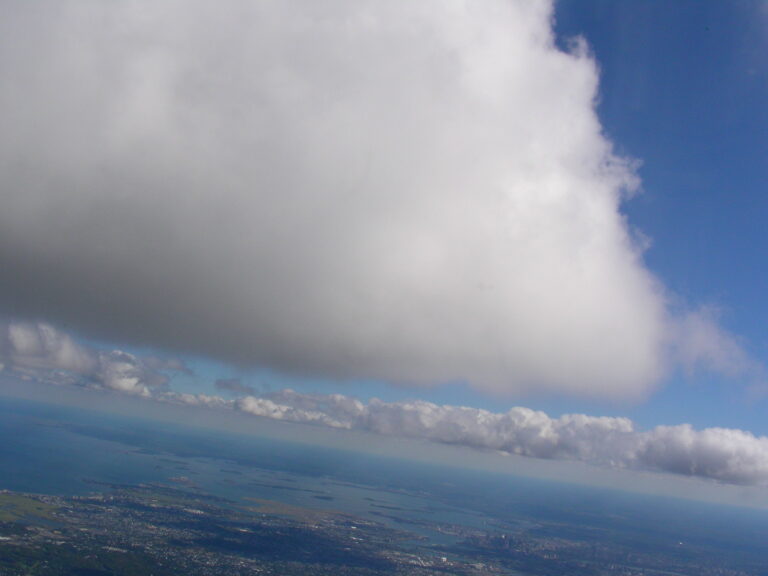 Towering cloud formation rising above the sky seen from an aerial perspective