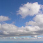 Large white cumulus clouds in blue sky – fine art cloudscape photography by Layne Morgan