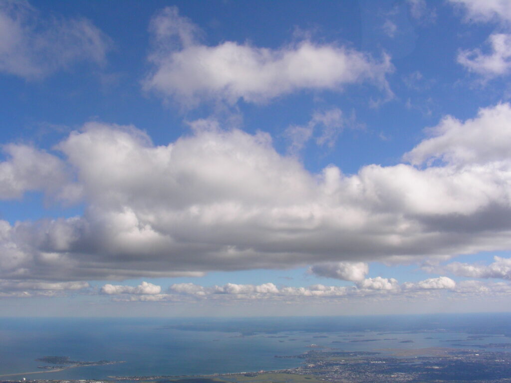 Cumulus clouds above distant horizon – fine art sky photography by Layne Morgan