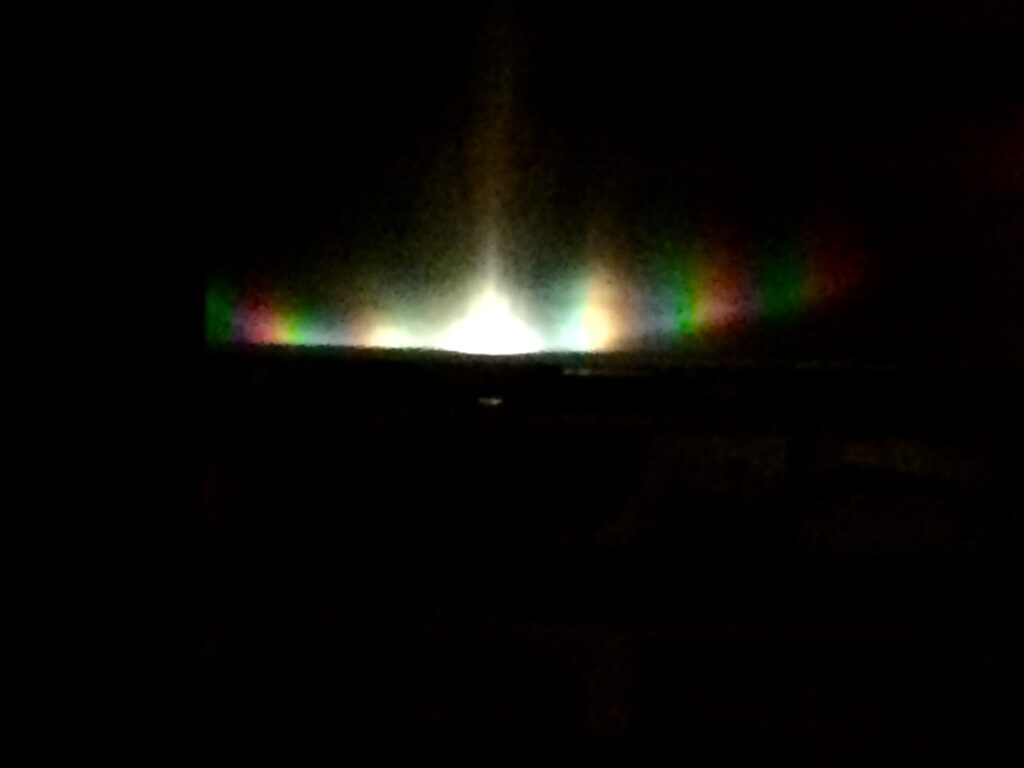 Abstract rainbow light refraction on dark background – fine art photography by Layne Morgan