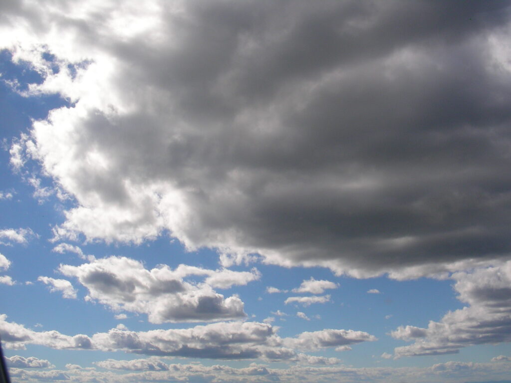 Dark storm clouds above blue horizon – fine art cloudscape photography by Layne Morgan