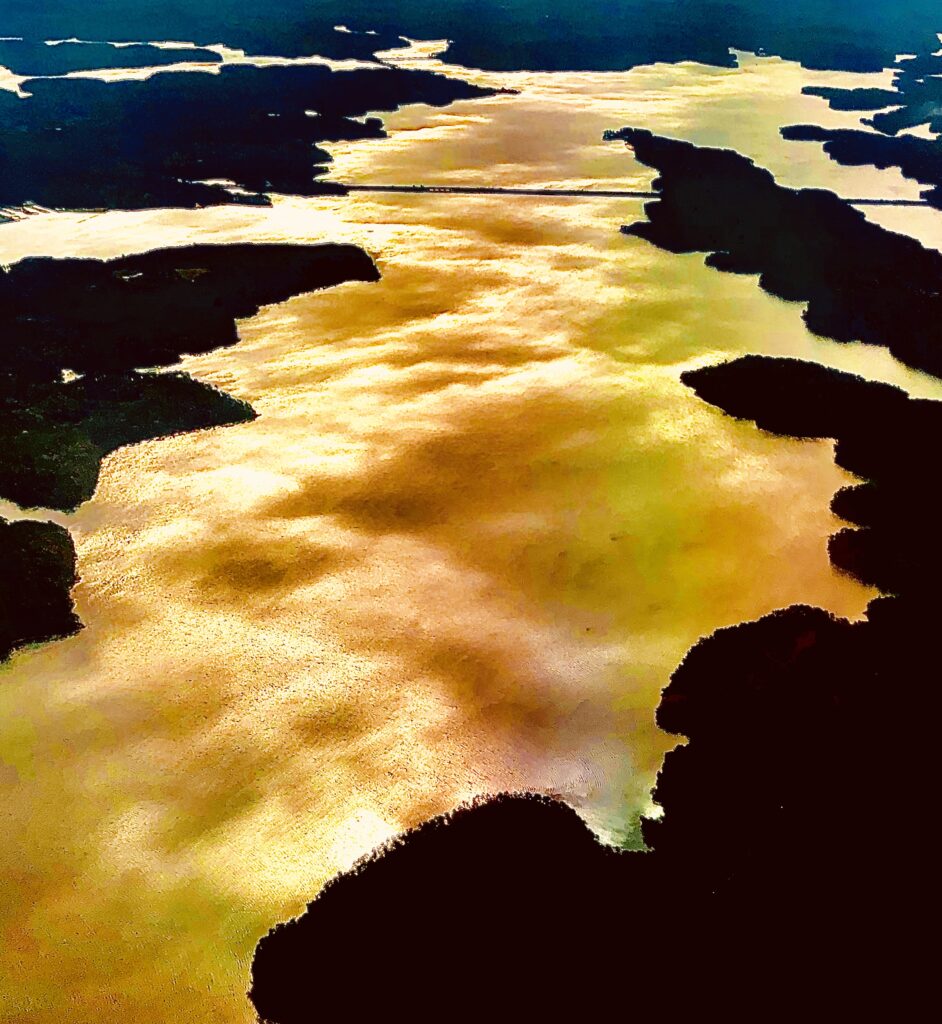 Golden light reflecting on water forming abstract shoreline patterns – fine art photography by Layne Morgan