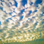 Golden patterned clouds across blue sky – fine art cloudscape photography by Layne Morgan