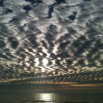 Ripple cloud formations above calm water horizon – fine art cloudscape photography by Layne Morgan