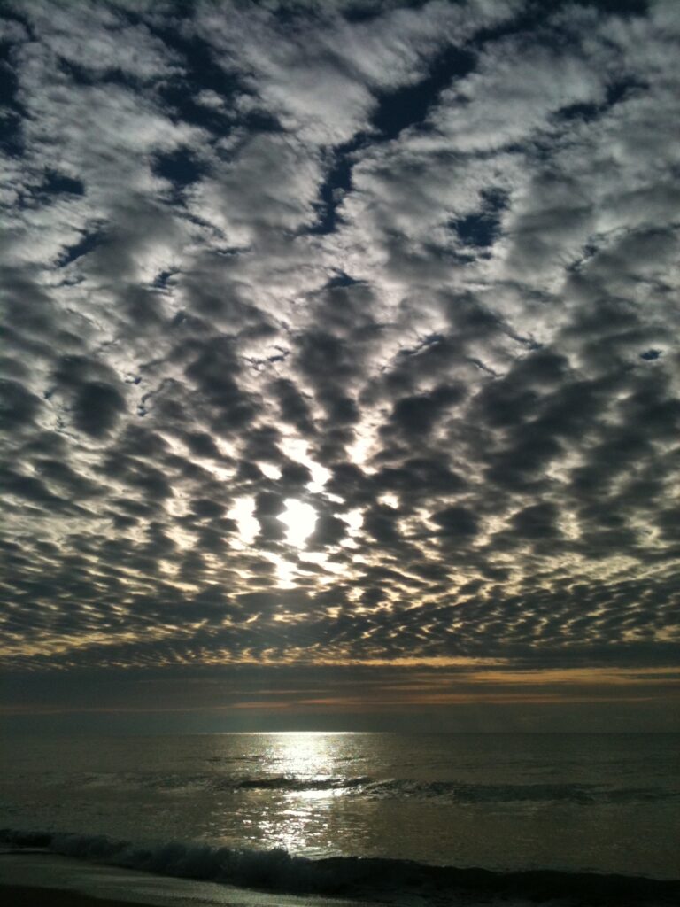 Ripple cloud formations above calm water horizon – fine art cloudscape photography by Layne Morgan