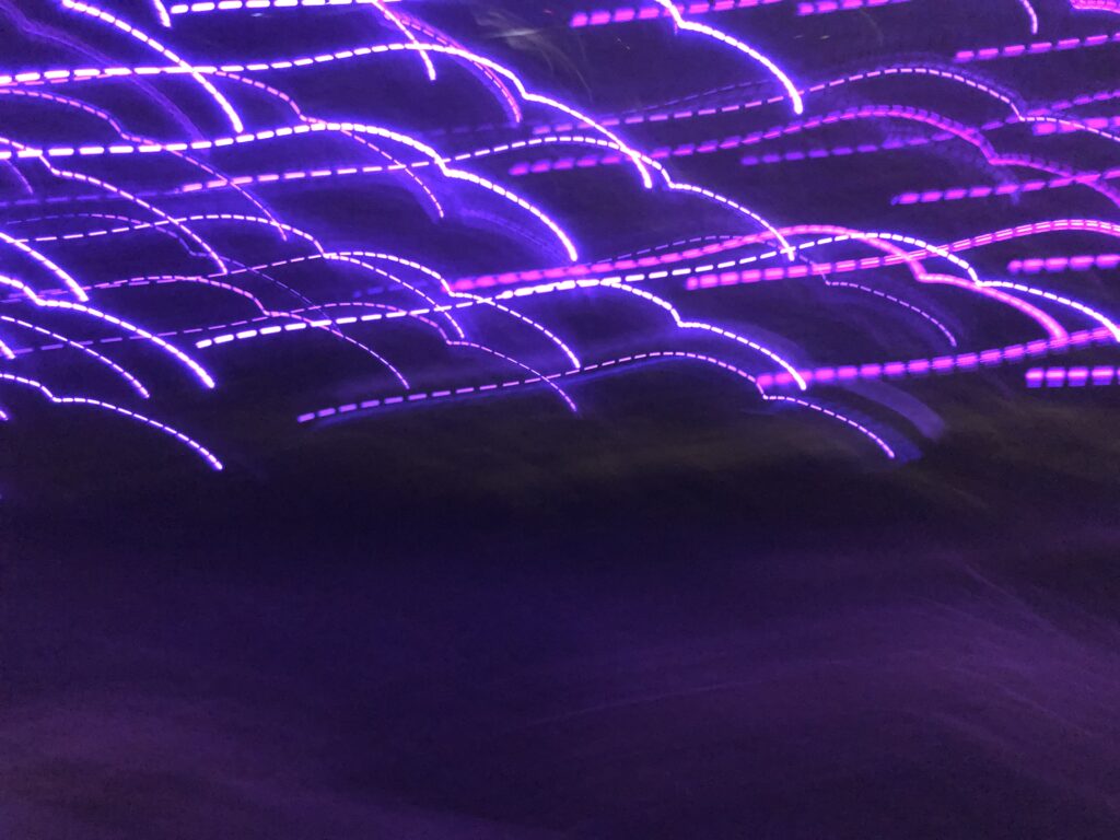 Purple long-exposure light trails forming abstract wave patterns – experimental photography by Layne Morgan