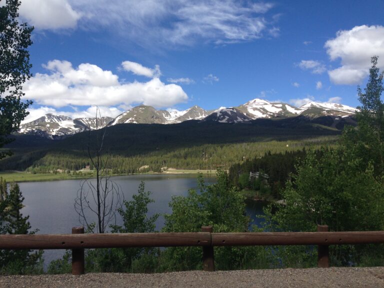 Aerial view of mountains and lake beneath dramatic clouds