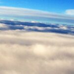 Aerial view of layered clouds and horizon – fine art cloudscape photography by Layne Morgan