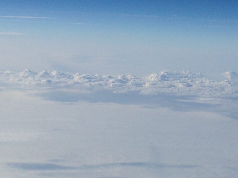 Aerial horizon view with soft cloud layers and pale blue sky