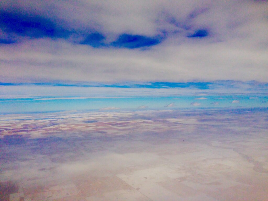 Pastel coastal shoreline with gentle ocean waves beneath layered clouds