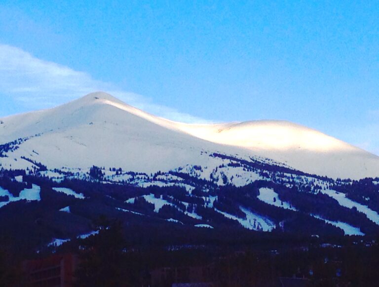 Snow covered mountain peak under blue sky landscape photography by Layne Morgan