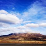 Rolling hills landscape under dramatic sky photography by Layne Morgan