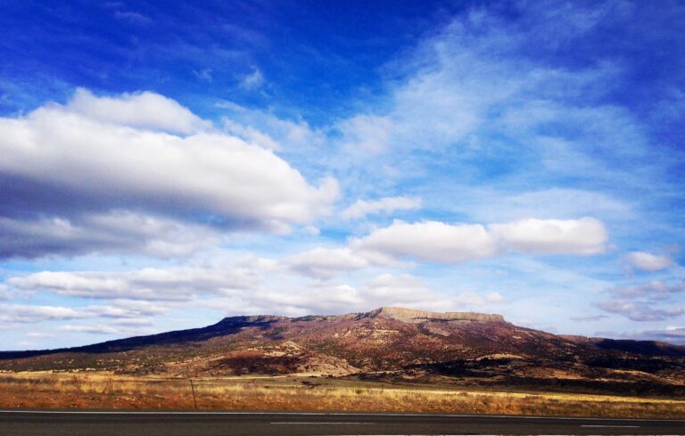 Rolling hills landscape under dramatic sky photography by Layne Morgan
