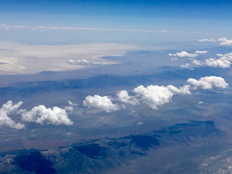 Aerial view of mountain ridges with clouds drifting above the landscape