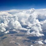 Aerial view of towering clouds above landscape – fine art cloudscape photography by Layne Morgan