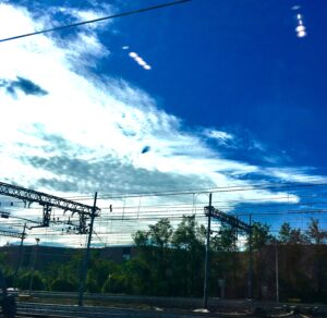 Power lines and electrical infrastructure beneath dramatic blue sky urban landscape photography by Layne Morgan