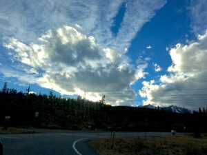 Dramatic clouds forming above urban horizon landscape photography by Layne Morgan