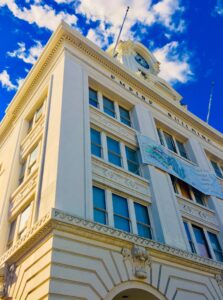 Historic yellow building facade with windows and architectural symmetry urban photography by Layne Morgan