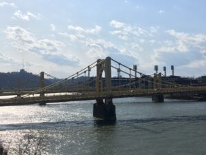 City bridge crossing water with skyline in background urban architecture photography by Layne Morgan