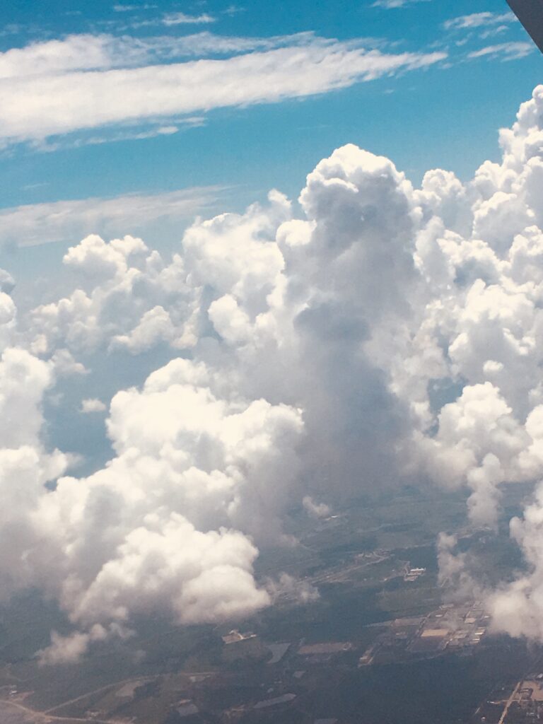 Towering white clouds rising above the landscape from an aerial perspective
