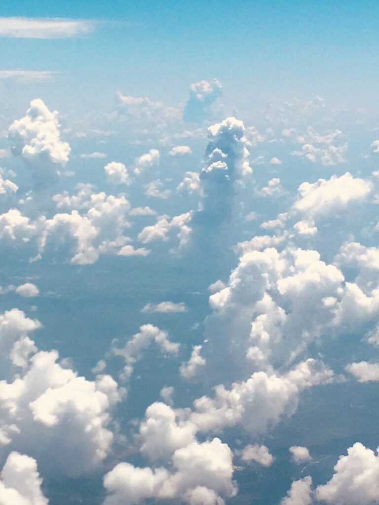 High-altitude aerial cloudscape with towering clouds and blue sky