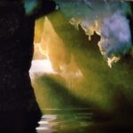 Sunlight streaming into a cave at Chena Hot Springs in Alaska with reflections on water captured by fine art photographer Layne Morgan