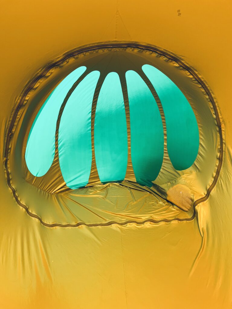 Abstract gold background with teal glowing geometric light pattern and curved symmetry