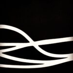 Abstract photograph of smooth white curved lines on a black background, creating a minimalist and modern fine art composition