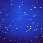 Abstract blue background with scattered light dots resembling stars, creating a minimalist fine art composition