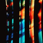 Abstract photograph of colorful vertical neon light streaks and reflections, creating an urban fine art composition with vibrant tones