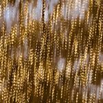 Abstract photograph of shimmering golden light particles creating a textured bokeh effect, elegant fine art photography composition